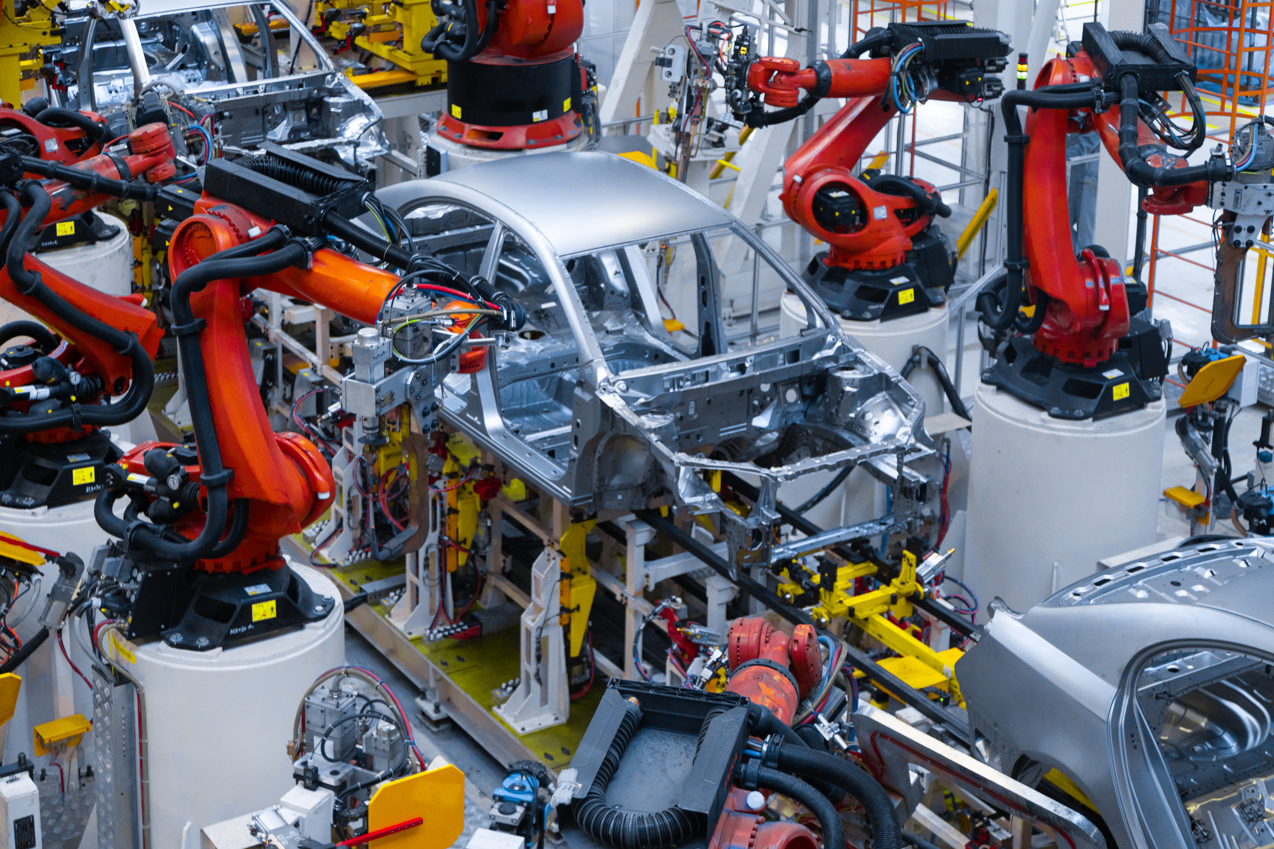 Robotic arms assembling vehicles on an automotive production line